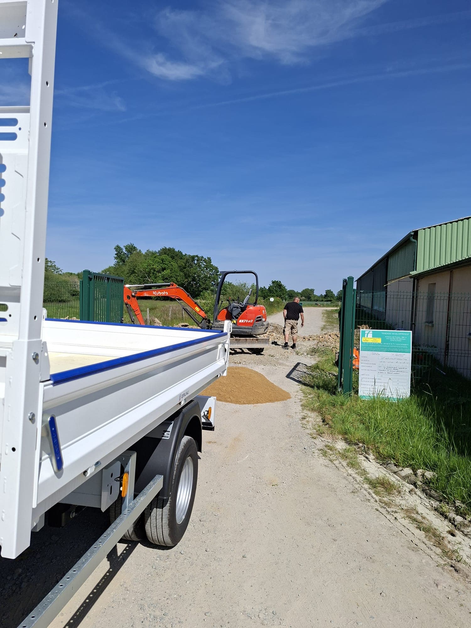 Equipe 2DY CONNECT sur le terrain avec camion-remorque et mini-pelle Kubota, depart d'intervention
