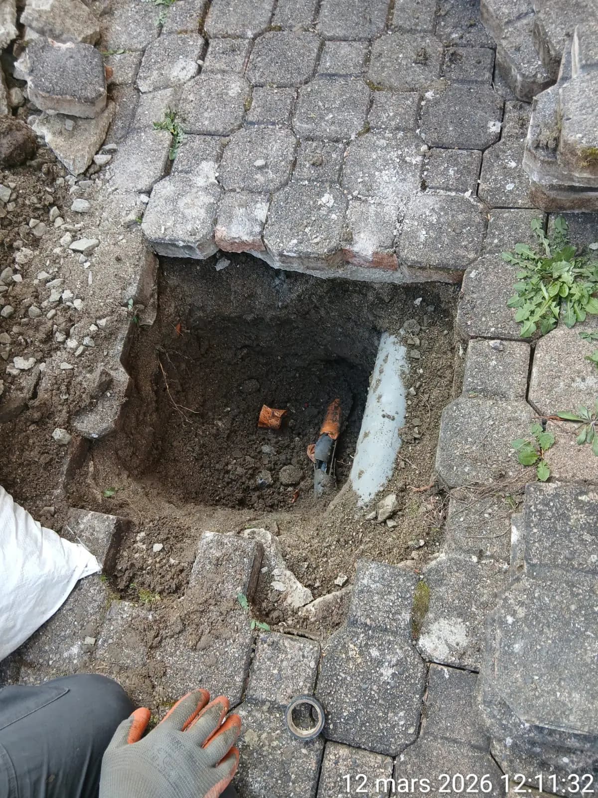 Regard decouvert sous des paves avec cable telecom apparent