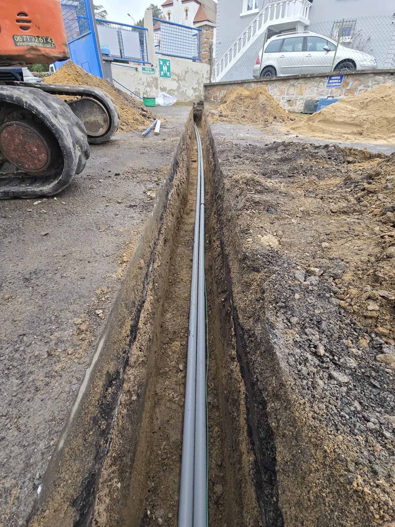 Longue tranchée fibre avec conduits PVC gris posés et pelle mécanique, prestation création de tranchée FOURREAU TÉLÉCOM